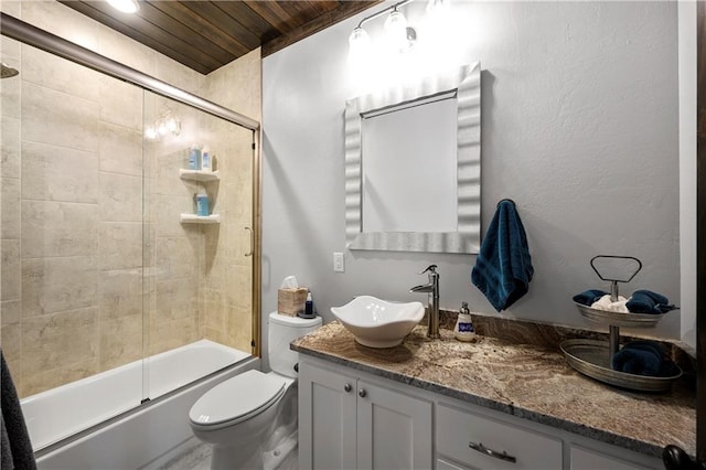 full bathroom with vanity, toilet, wooden ceiling, and bath / shower combo with glass door