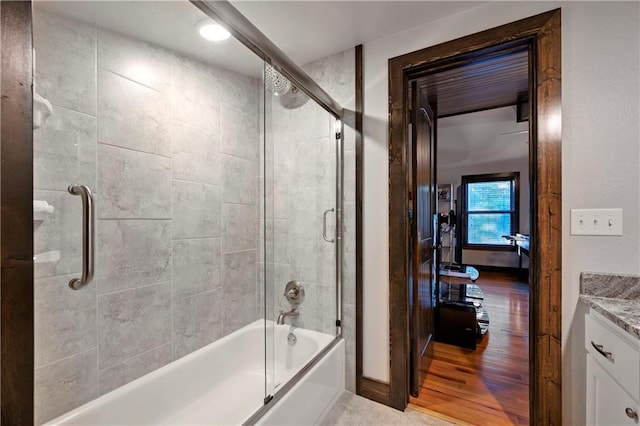 bathroom with vanity, enclosed tub / shower combo, and hardwood / wood-style flooring