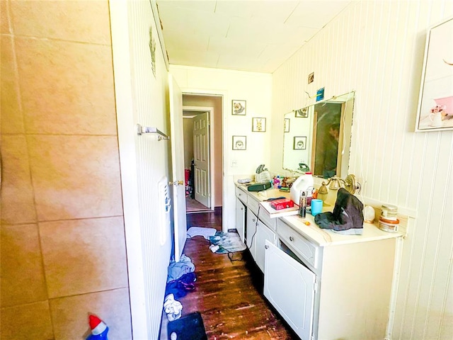 bathroom featuring wooden walls, hardwood / wood-style floors, and vanity