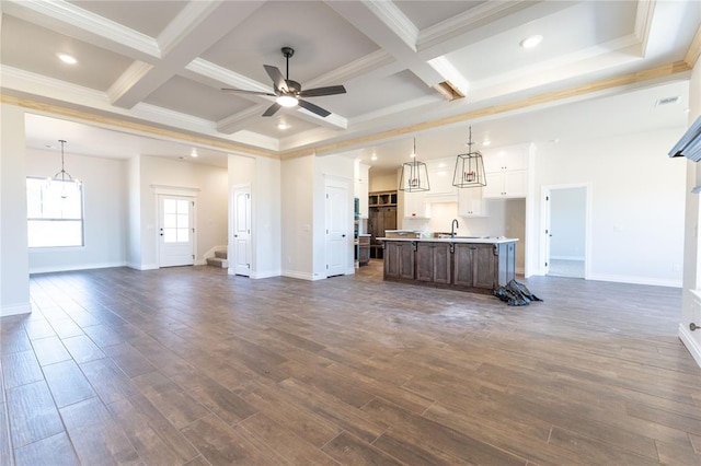 unfurnished living room featuring beamed ceiling, ceiling fan, dark hardwood / wood-style flooring, and sink