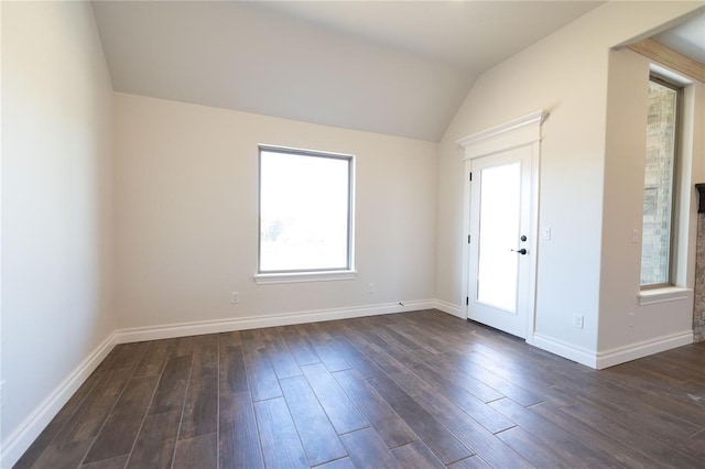 foyer featuring dark wood-type flooring and vaulted ceiling