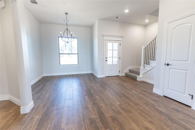 foyer featuring plenty of natural light, a chandelier, and dark hardwood / wood-style floors