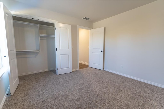 unfurnished bedroom featuring carpet flooring and a closet