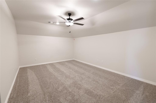 carpeted spare room featuring ceiling fan and vaulted ceiling