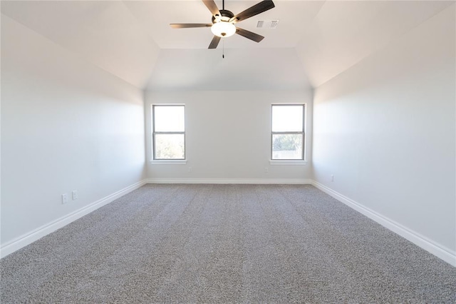 empty room with ceiling fan, vaulted ceiling, and a wealth of natural light