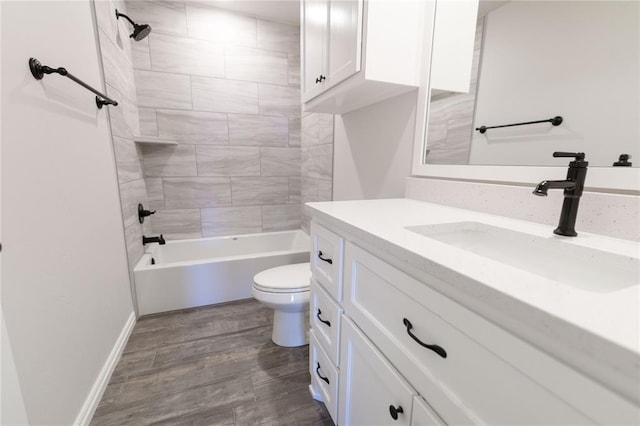 full bathroom with tiled shower / bath combo, vanity, wood-type flooring, and toilet