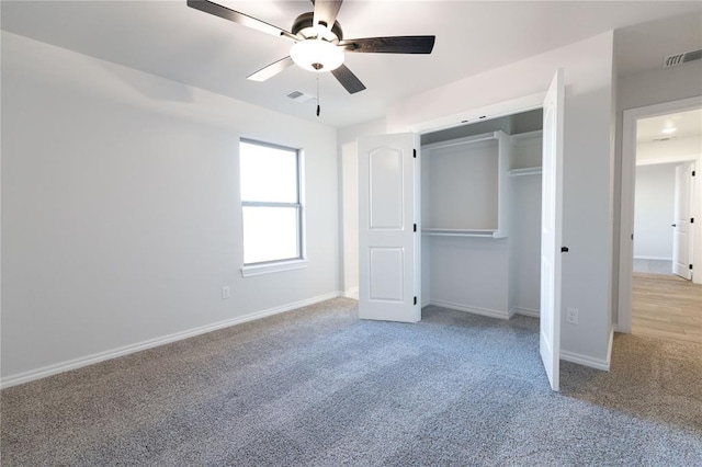 unfurnished bedroom with ceiling fan, a closet, and light carpet