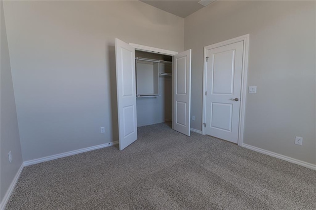 unfurnished bedroom featuring carpet flooring and a closet