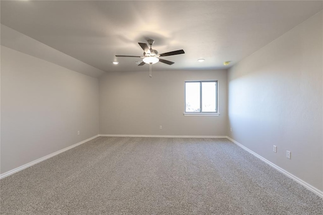 empty room featuring lofted ceiling, carpet floors, and ceiling fan