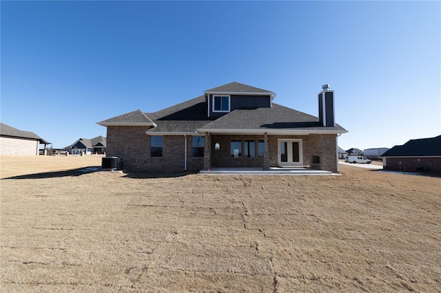 back of property with central AC and a patio