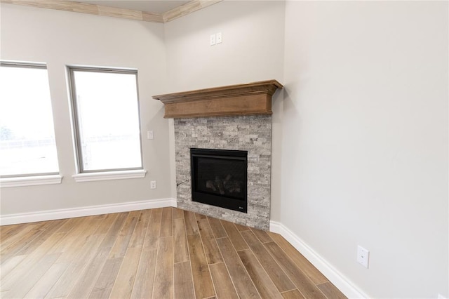 unfurnished living room with wood-type flooring, a fireplace, and crown molding