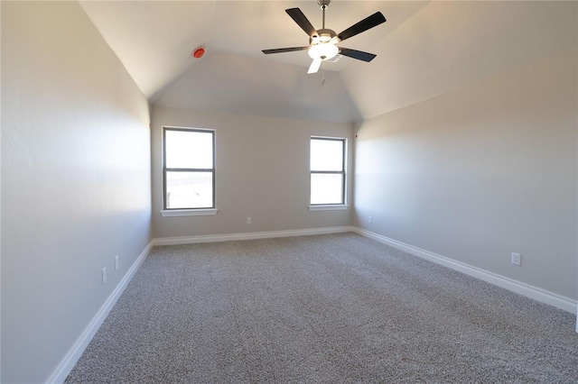 spare room with ceiling fan, vaulted ceiling, and carpet