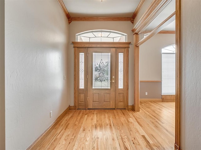 foyer with light hardwood / wood-style flooring and ornamental molding