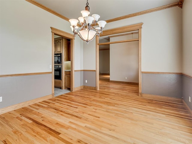 unfurnished room with ornamental molding, a chandelier, and light wood-type flooring