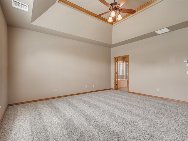 spare room featuring carpet flooring, ceiling fan, and a raised ceiling