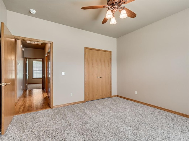 unfurnished bedroom with carpet flooring, ceiling fan, and a closet