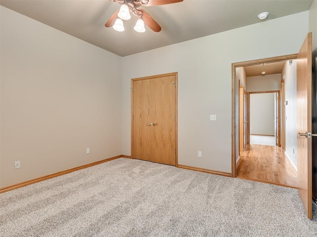 unfurnished bedroom with carpet, a closet, and ceiling fan