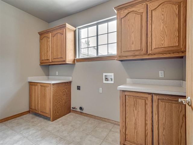 washroom with hookup for an electric dryer, light tile patterned flooring, cabinets, and washer hookup