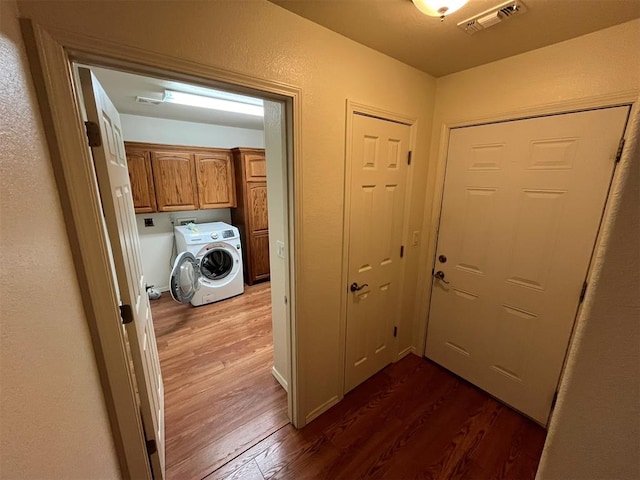 interior space with cabinets, washer / dryer, and dark hardwood / wood-style floors