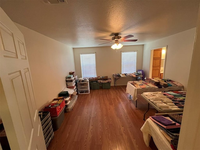 bedroom with wood-type flooring, a textured ceiling, and ceiling fan