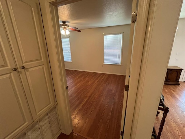 hallway featuring wood-type flooring and a textured ceiling