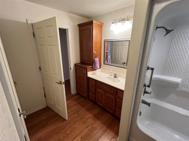 bathroom featuring hardwood / wood-style floors, vanity, and washtub / shower combination