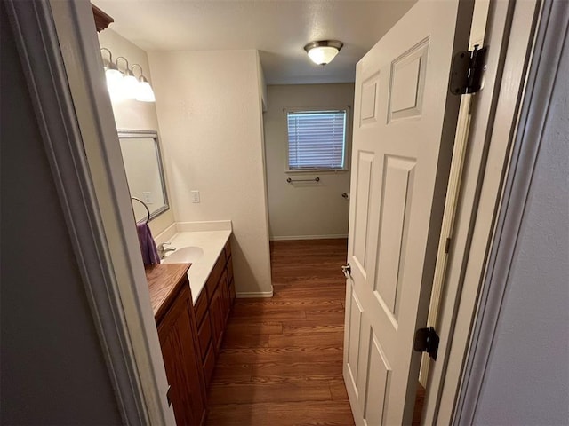 208 N Kay Dr, Broken Bow, OK 74728 - bathroom with wood finished floors, vanity, and baseboards