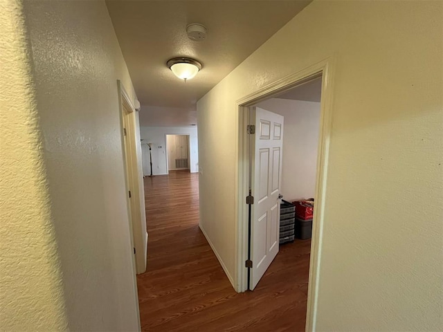 208 N Kay Dr, Broken Bow, OK 74728 - corridor with dark wood-style flooring, a textured wall, and baseboards