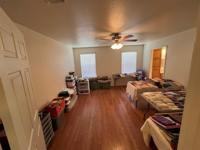 208 N Kay Dr, Broken Bow, OK 74728 - bedroom with wood finished floors, ceiling fan, a textured ceiling, and ensuite bath