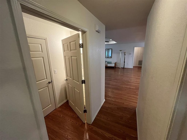 208 N Kay Dr, Broken Bow, OK 74728 - corridor featuring wood finished floors, a textured wall, and baseboards