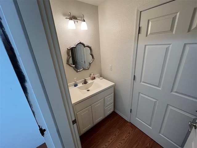 208 N Kay Dr, Broken Bow, OK 74728 - bathroom with wood finished floors, vanity, and a textured wall