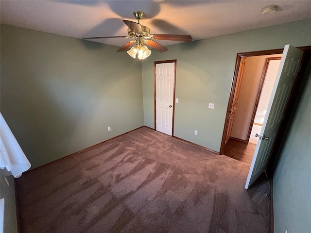 unfurnished bedroom featuring ceiling fan and dark colored carpet