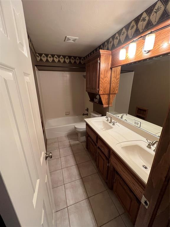 full bathroom with tile patterned floors, vanity, toilet, and washtub / shower combination