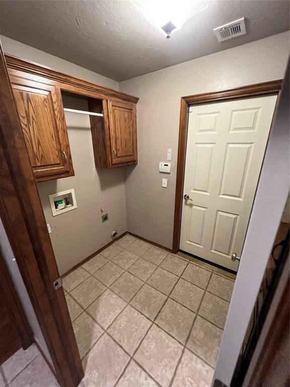 clothes washing area featuring cabinets, light tile patterned floors, electric dryer hookup, and washer hookup