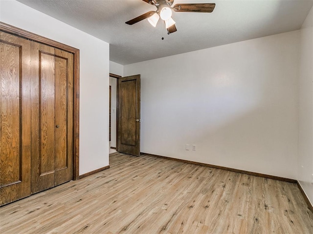 unfurnished bedroom with ceiling fan, light hardwood / wood-style floors, and a closet