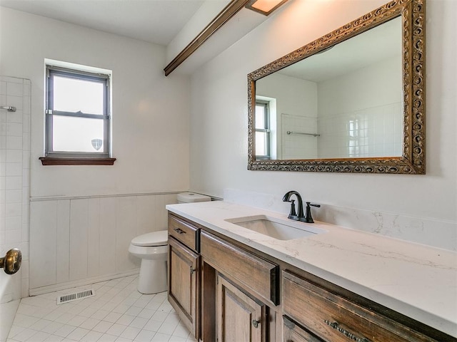 bathroom featuring wooden walls, tile patterned flooring, vanity, and toilet