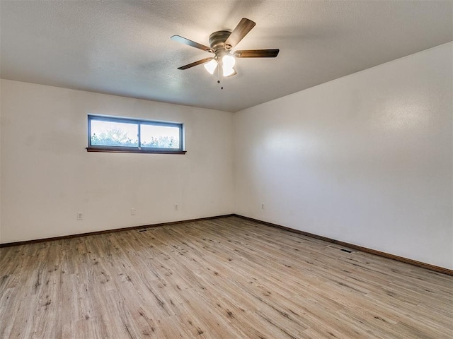 empty room featuring a textured ceiling, light hardwood / wood-style flooring, and ceiling fan