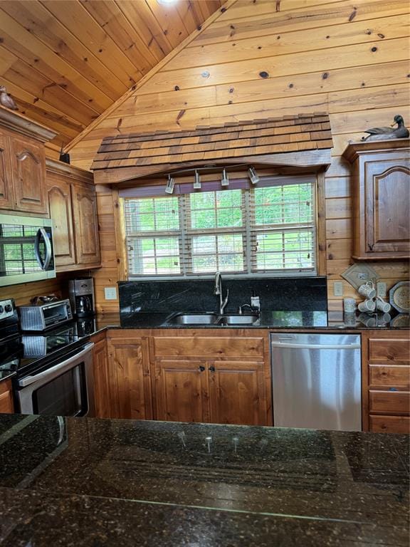 kitchen with appliances with stainless steel finishes, dark stone counters, wood ceiling, sink, and lofted ceiling