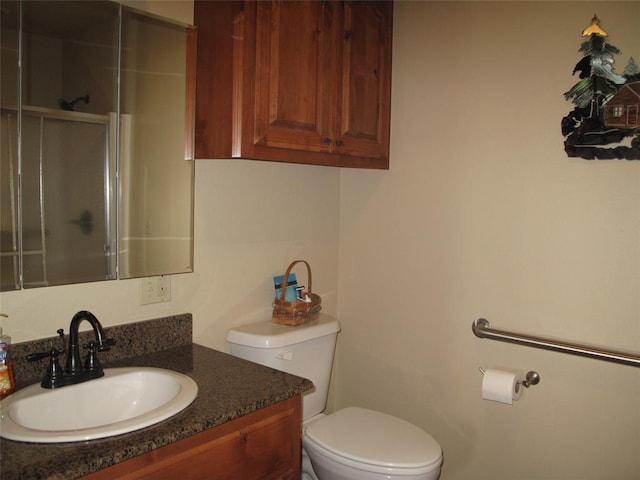 bathroom with vanity, toilet, and a shower with shower door