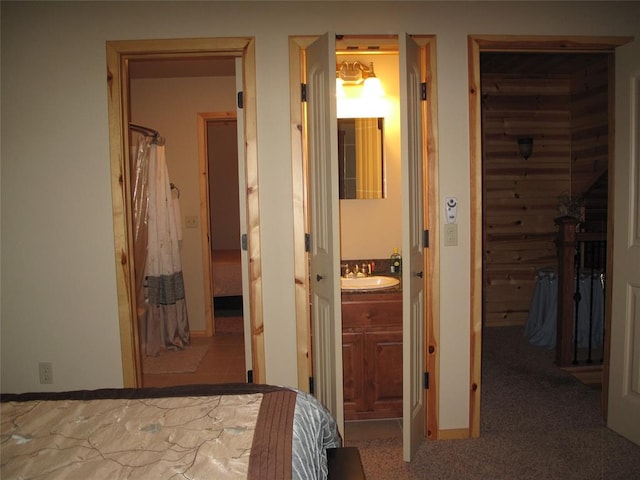 unfurnished bedroom featuring a spacious closet, sink, ensuite bathroom, a closet, and carpet