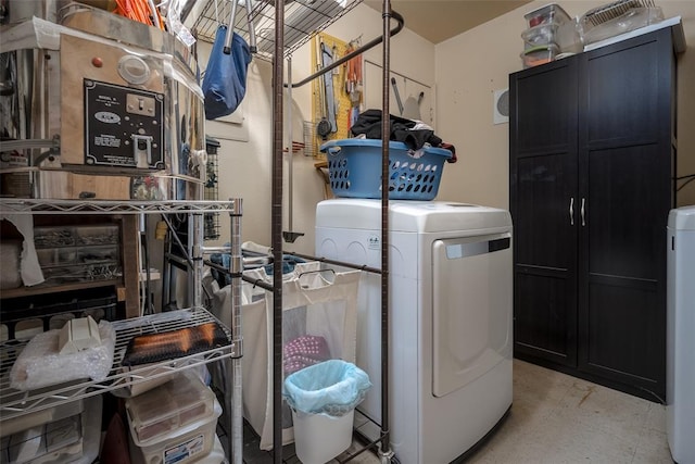 laundry area with washer and clothes dryer and cabinets