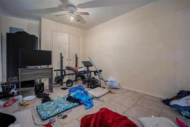 workout room featuring ceiling fan and light tile patterned floors