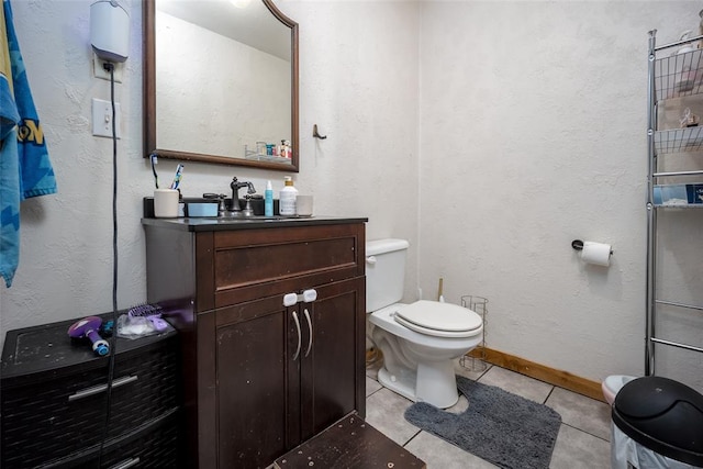 bathroom with toilet, vanity, and tile patterned floors