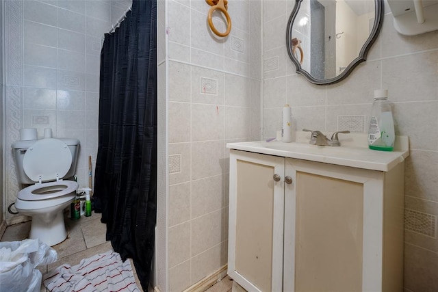 bathroom featuring tile patterned flooring, vanity, tile walls, and toilet