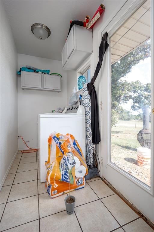 laundry room featuring separate washer and dryer, light tile patterned flooring, and cabinets