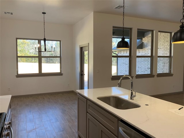 kitchen with dark wood-type flooring, sink, hanging light fixtures, dishwasher, and stove