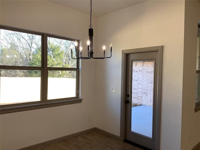 unfurnished dining area featuring dark hardwood / wood-style flooring and a notable chandelier