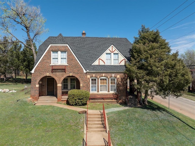 english style home featuring a front yard