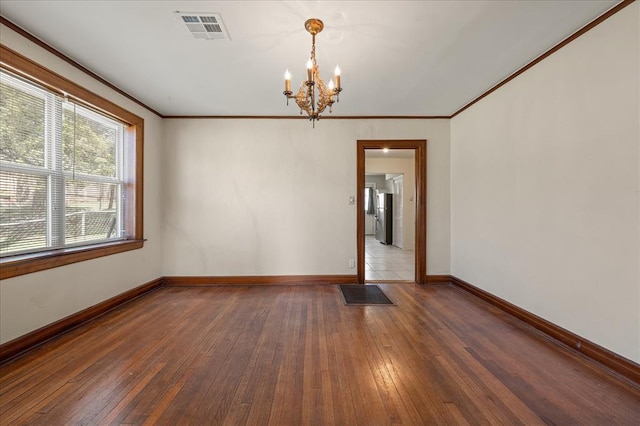 unfurnished room with crown molding, dark hardwood / wood-style floors, and an inviting chandelier