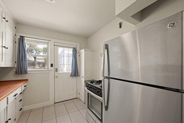 kitchen with white cabinets, stainless steel appliances, and light tile patterned flooring